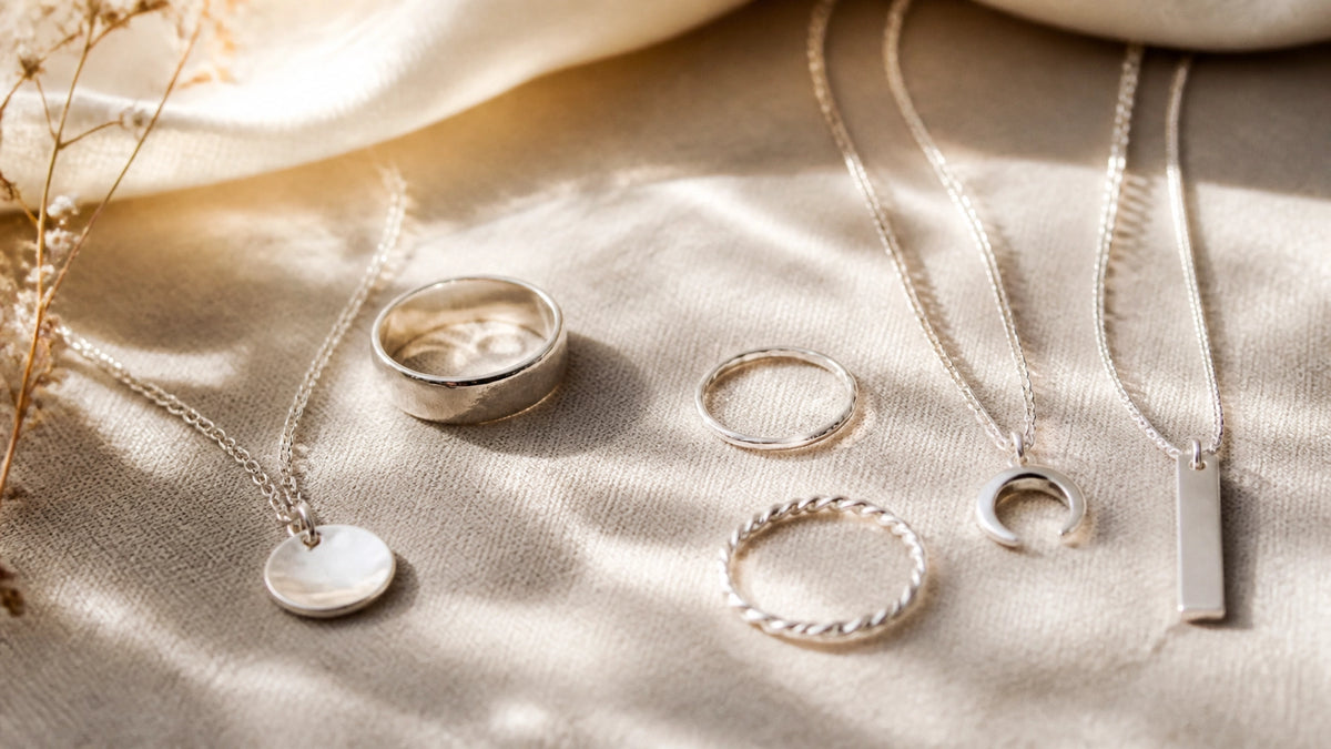 Elegant sterling silver jewelry laid out on soft linen with natural sunlight